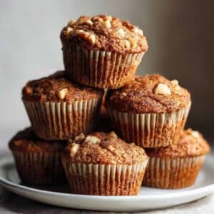 Stack of healthy apple muffins with nuts on ceramic plate